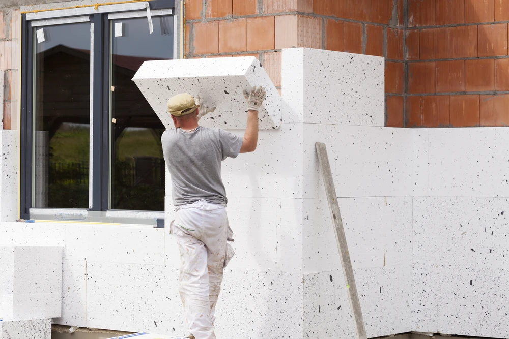 Chantier de construction résidentielle en cours, façade d'une maison moderne avec isolation thermique extérieure