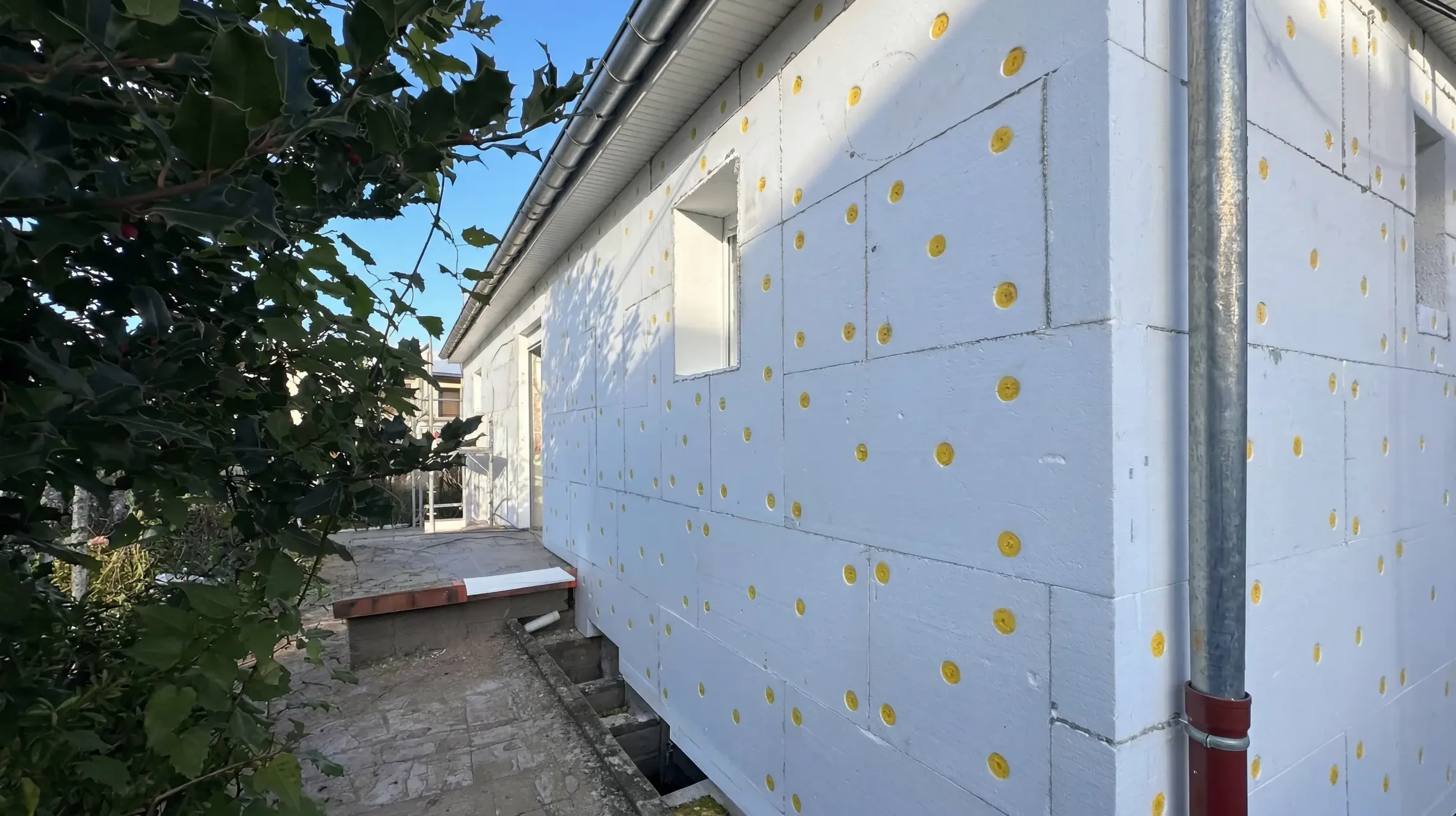 Chantier de rénovation extérieure d'immeuble résidentiel avec ouvriers sur échafaudage tubulaire
